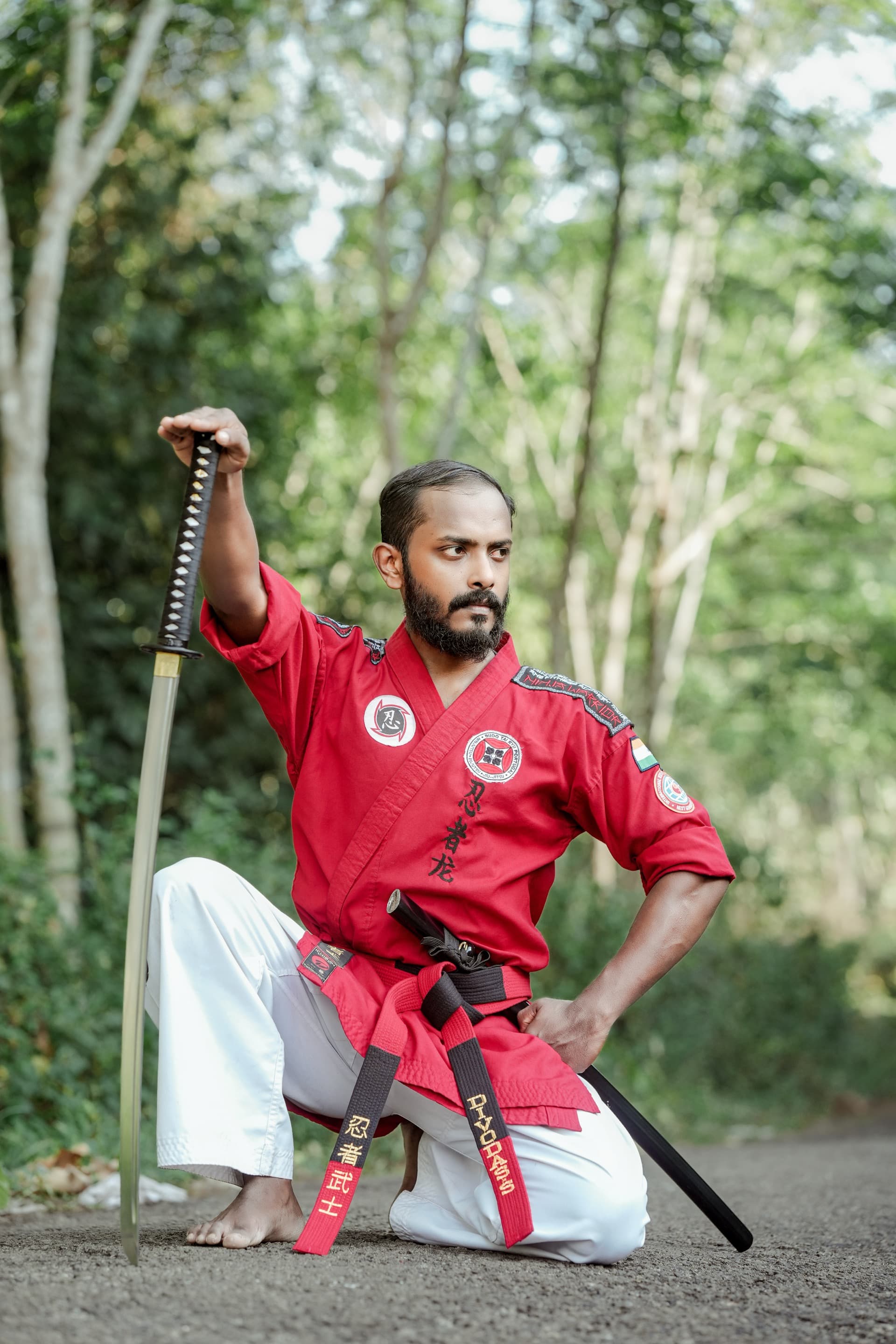 Master Divo Das kneeling stance with sword